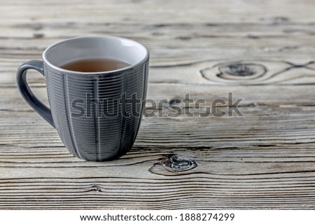 Tea cup Ultimate Gray color on a wooden background, copy space