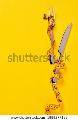 Tape measure on a fork and a knife