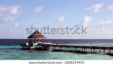 Berth for sea boats and yachts on the background of the sky landscape. Pier for marine vessels built on stilts on a tropical ocean island. 