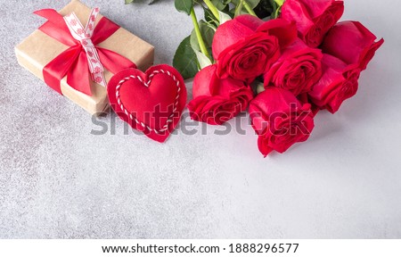 Beautiful red roses, gift box and decorative textile heart on stone background. Valentine's day concept - Image