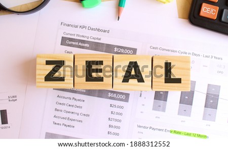 Wooden cubes with letters on the table in the office. Text ZEAL. Financial concept.