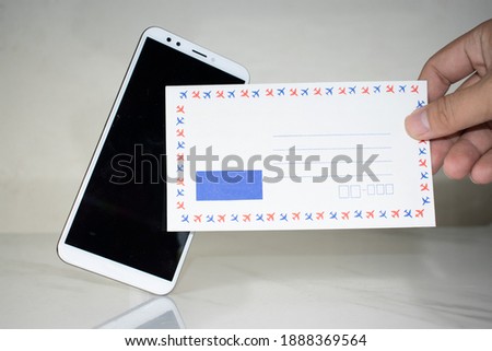 Man holding paper envelope In front of a smartphone mockup