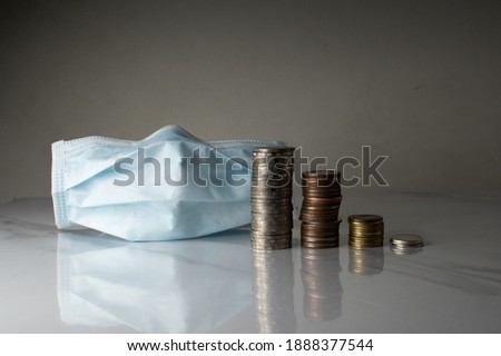  coins of Thailand and a medical mask on a white background. Thailand money and a medical mask.