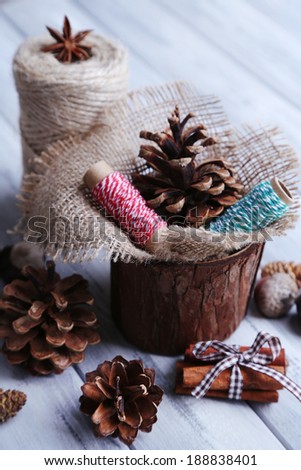Composition with natural bump, thread, cinnamon sticks on wooden background