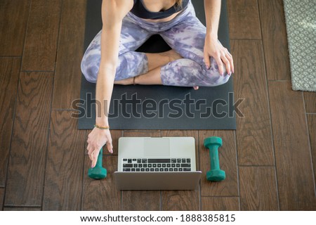 Young woman on yoga mat taking exercise class Royalty-Free Stock Photo #1888385815