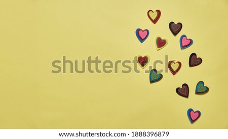 Greeting card or banner for Valentine's Day. multicolored hearts on a yellow background top view. flat lay.