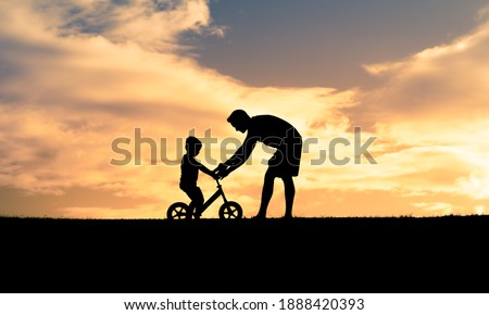 Father teaching his son to ride a bicycle. Parenting, and childhood lifestyle concept.   