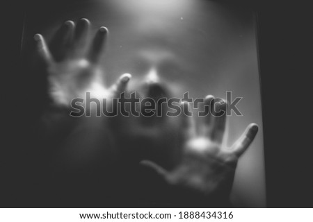 scary picture of hands behind glass
