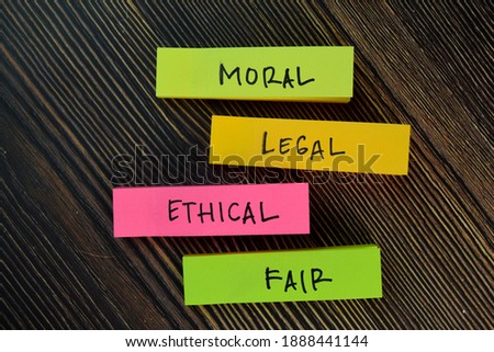 Moral - Legal - Ethical - Fair write on sticky notes isolated on Wooden Table.