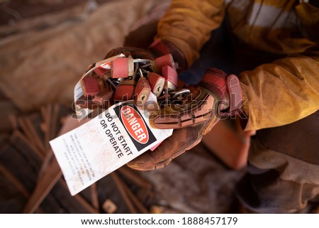 safety workplaces construction worker holding inspecting bunches of danger personal locks attached with danger tag prior locking on the permit and working on moving machinery equipment 
 Royalty-Free Stock Photo #1888457179