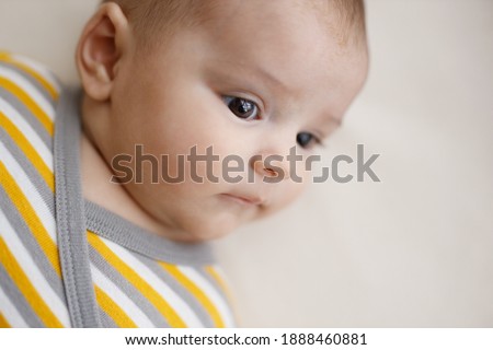 Adorable baby in a white sunny bedroom. Newborn baby is resting in bed. Family morning at home.