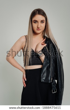 Studio photo of girl in black dress. White background. Hipster look