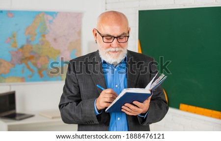 teacher of geography. classroom with map and blackboard. back to school. education in retro school. bearded man give marks in diary. write notes. senior teacher make notes. move on to the next stage.