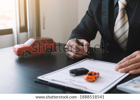 Businessmen are sitting down to read the details of the car rental or purchase form to decide when to sign a purchase contract.