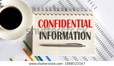 CONFIDENTIAL INFORMATION text written on notebook with pen and chart