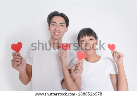 Valentines day and love. Romantic feelings concept. Man and woman couple in love hold red heart card on white background. 


