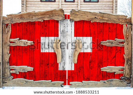 Close-up of the national flag of Switzerland on a wooden gate at the entrance to the closed territory. The concept of storage of goods, entry to a closed area. 