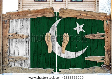 Close-up of the national flag of Pakistan on  wooden gate at the entrance to the closed territory. The concept of storage of goods, entry to a closed area. 