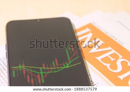 Close Illustration Photo for Article about Stock Exchange, Candle Stick Graphic at Smartphone and Newspaper