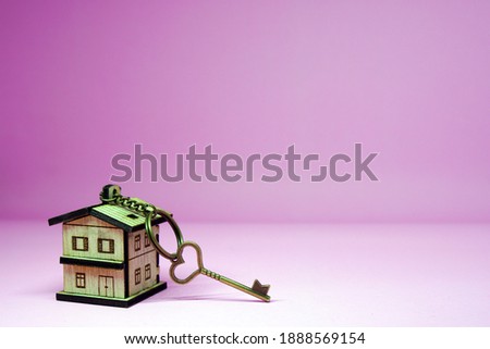 Vintage House key with home keyring on pink background and copy space - New home concept 