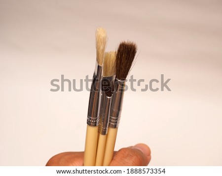 Set of painting brush with wooden handle, laid on a white isolated background