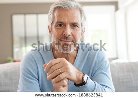 Portrait of attractive senior man with blue sweater relaxing at home Royalty-Free Stock Photo #1888623841