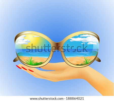Sunglasses with the reflection of the summer sea landscape lie on hand