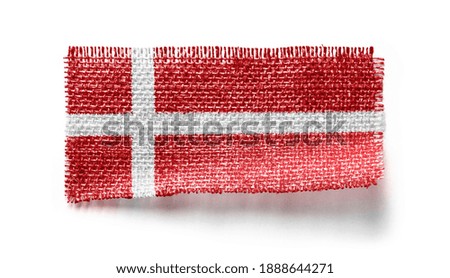 Denmark flag on a piece of cloth on a white background