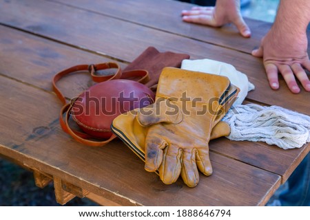 set of hunter accessories leather jar round and gloves folded on the table