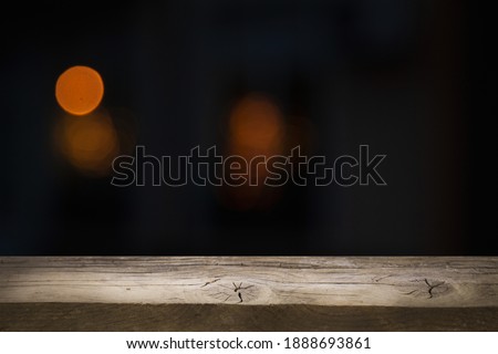 empty table on dark background with blurred lamps, cafe restaurant bokeh for your product or customization