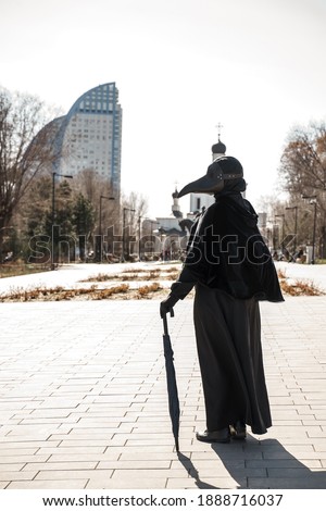 plague doctor in an empty city on the background of the temple