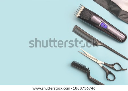 barber tools on blue background. hair clipper, comb, scissors and brush. man hair stylist equipment. male beauty care. home hair cut tools. hairdresser electric machine. Royalty-Free Stock Photo #1888736746