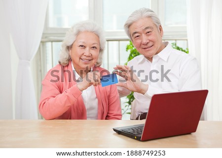 An old senior couple holding credit card high quality photo