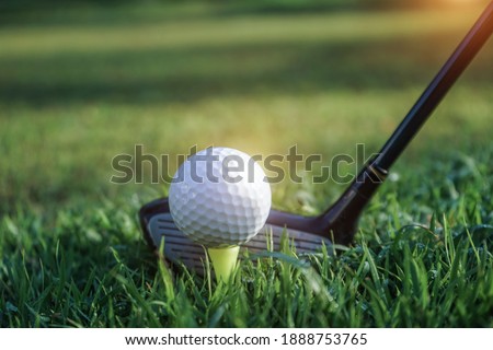 Golf club and golf ball close up in grass field with sunset. Golf ball close up in golf coures at Thailand.                                 Royalty-Free Stock Photo #1888753765
