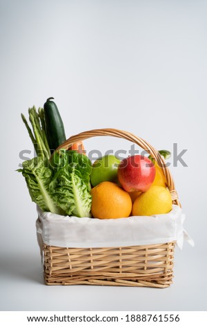 Organic vegetables and fruits in wicker basket isolated on white background. Royalty-Free Stock Photo #1888761556