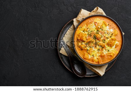 Murgh Makhani or Butter Chicken in black bowl on dark slate table top. Indian Cuisine dish with chicken meat and creamy masala. Asian food and meal. Copy space. Top view Royalty-Free Stock Photo #1888762915