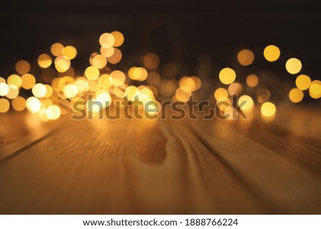 Empty wooden surface and blurred lights on background. Bokeh effect