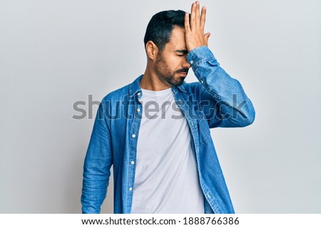 Young hispanic man wearing casual clothes surprised with hand on head for mistake, remember error. forgot, bad memory concept.  Royalty-Free Stock Photo #1888766386
