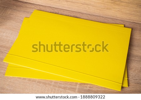 Two yellow A4 folders. The photo. In the interior. For text or image. Nearby are dried flowers in vases..

