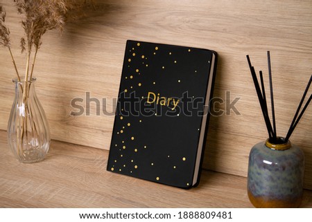 Black diary. The photo. In the interior. For text or image. Nearby are dried flowers and incense sticks..