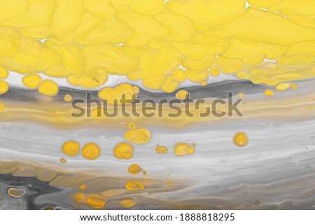 Gray paint Waves with yellow bubbles drops. Marble effect background or texture. Fluid Art. Trending colors of 2021.