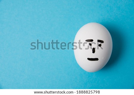 An egg with an indifferent face. Isolate on a blue background. The emotion of indifference on the face.