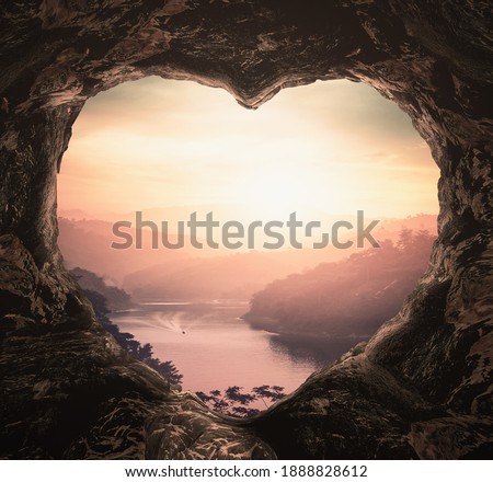 Inspire concept: Heart shape of cave on river and beautiful bright mountains sunset background