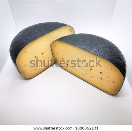 Wax-coated cheese wheel with truffles cut into two pieces picture taken in a lightbox