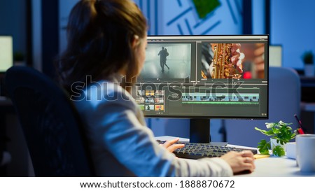 Video editor working at night at new project editing audio film montage sitting in start-up business office. Woman content creator using professional computer, modern technology, network wireless Royalty-Free Stock Photo #1888870672