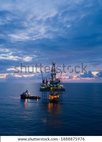 Aerial view offshore drilling rig (jack up rig) at the offshore location during sunset Royalty-Free Stock Photo #1888875976
