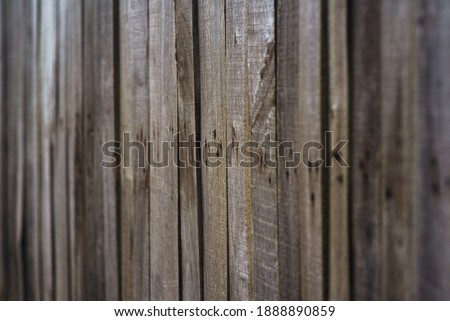 Relief, vintage texture of a rough, wooden fence made of wooden, vertical bars knocked down together. Wet, prefabricated surface of wood.