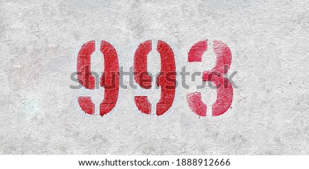 Red Number 993 on the white wall. Spray paint.