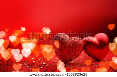 Festive background for valentine's day with copy space. Heart shaped two hearts on a red background with sparkles and bokeh.