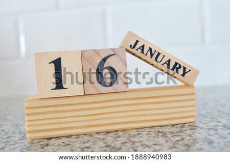 January 16, Cover design with number cube on a white background and granite table.
